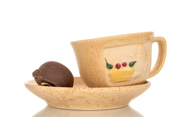 One chocolate candi with ceramic dishes, close-up, isolated on white background.