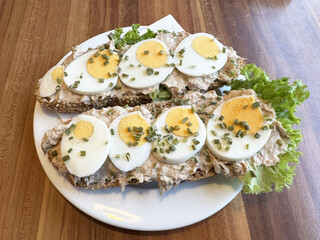 Tuna salad sandwich with sliced egg and chives on whole wheat bread