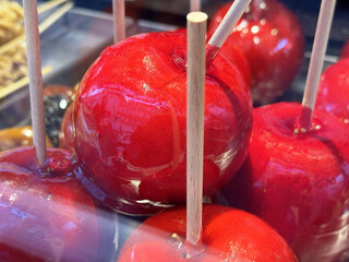 Bright red candy apples with wooden sticks at a market stall