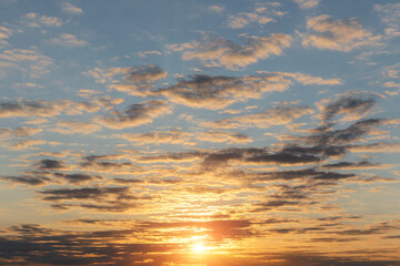 Beautiful soft sunrise, sunset yellow orange blue sky with sun, sunlight and clouds background texture