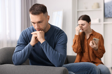 Upset couple after quarrel at home, selective focus