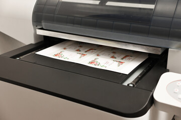 Modern printer with printed wedding invitation cards indoors, closeup. Printing house