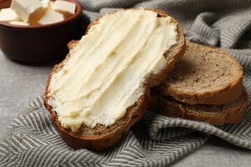 Fresh bread with butter on grey table, closeup