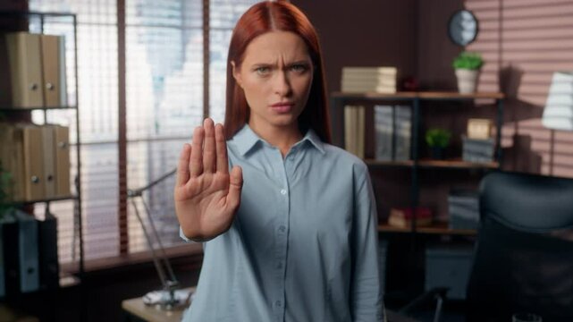 Serious Caucasian business woman girl female businesswoman in office not deny reject gesture forbidden bad prohibit stop palm put in front border keep distance restriction refusal looking at camera