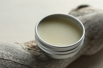 Natural solid perfume in container and snag on white table, closeup