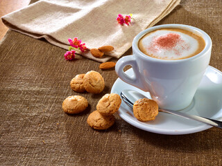 Cappucchino mit Milchschaum Keksen und Blueten, Italien, Cafe, Amarettini,