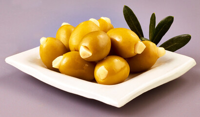 Griechische Oliven gefuellt auf weissem Teller, isoliert, grüne Oliven, Antipasti, 