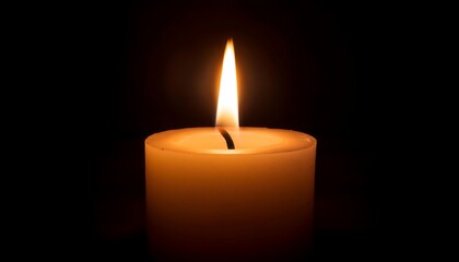 A lit candle glowing in darkness.