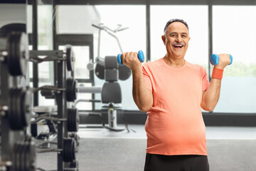 Happy mature man exercising with dumbbells and smiling