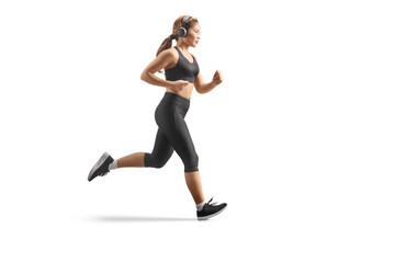 Full length profile shot of a young asian woman jogging with headphones