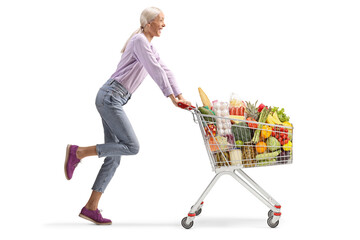 Woman running and pushing a shopping cart with groceries