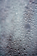 Close Up of Condensation Floating Liquid Water Bubbles and Drips on Glass from Rain