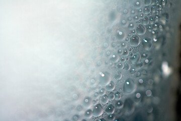 Close Up of Condensation Floating Liquid Water Bubbles and Drips on Glass from Rain