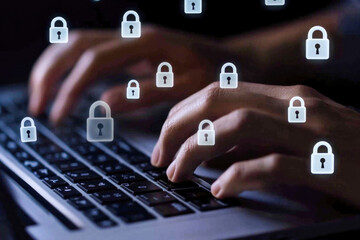 Cybersecurity concept: hands typing on a laptop with security icons overlay