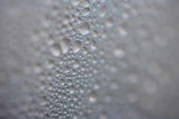 Close Up of Condensation Floating Liquid Water Bubbles and Drips on Glass from Rain