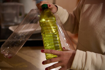 Person holding plastic bottles with one featuring a yellow liquid