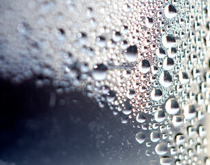 Close Up of Condensation Floating Liquid Water Bubbles and Drips on Glass from Rain