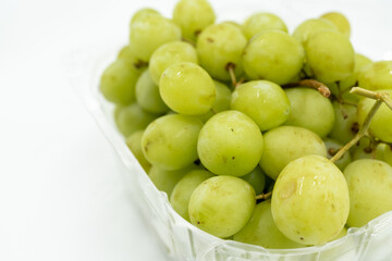 Fresh green grapes in clear plastic container, juicy and healthy
