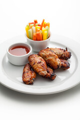 grilled chicken wings with sauce and vegetables