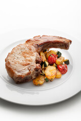 pork chop with baked potato and vegetables