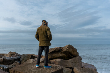 man with his back turned looking at the sea