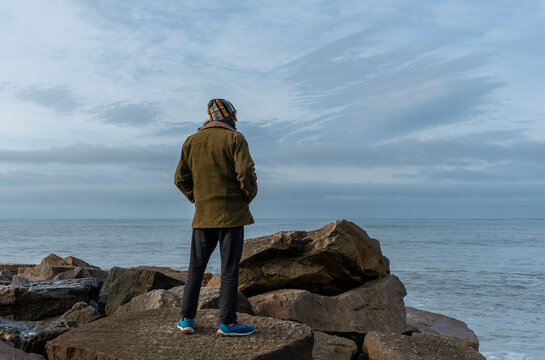 man with his back turned looking at the sea