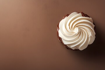 Chocolate cupcake with swirled vanilla frosting on brown background