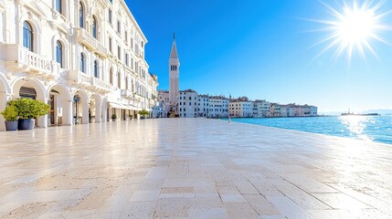 Naklejka premium Sunny waterfront promenade in Venice with historic buildings and the St. Mark's Campanile bell tower under a clear blue sky.