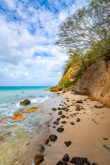 Anse Meunier is a small, secluded sandy beach on the tropical dream island Martinique (France) in the Caribbean. Idyllic landscape with turquoise water, blue sky, waves, rocks and typical vegetation
