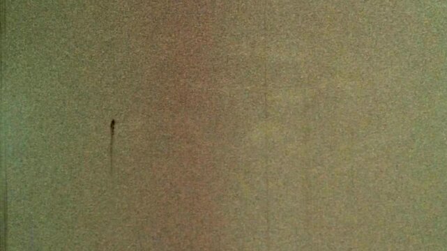 Looped noisy, grainy background beige film archive. Aged backdrop natural orange with scratches. Seamless loop old archival video. Dirty grunge overlay noise in retro abstract video. Vintage texture