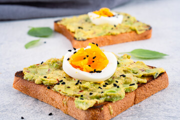 Healthy avocado toasts with eggs on table