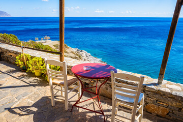Two chair and table is small coffee bar on sea coast near Agia Anna beach, Amorgos island, Cyclades, Greece