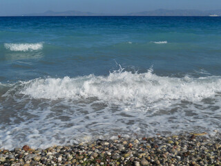 Waves crashing on a rocky beach at midday