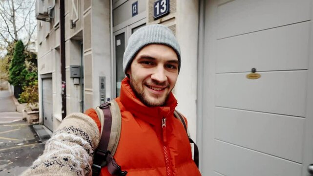 Young positive attractive man dressed trendy clothes recording video blog live streaming while walking on city streets. The guy walks around Belgrade - capital of Serbia, and shoots a travel blog