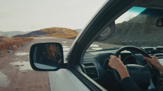 Young woman steers the big 4x4 car on a bumpy unpaved road
