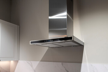 Modern metal kitchen hood on a white kitchen