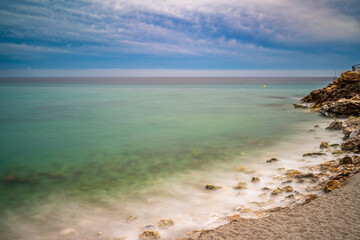 Serene Torrecilla Beach in Nerja Captivating Long Exposure Coastal View