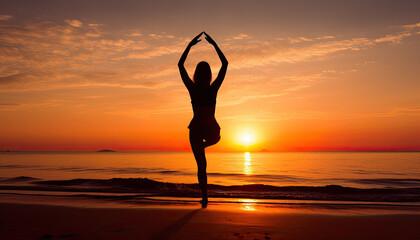 Girl practicing yoga on a rocky beach at sunrise in tree pose.