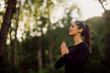 Calm woman practicing yoga in a park