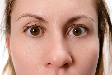 Close-up view of a woman's face with wide, surprised eyes and raised eyebrows, conveying a sense of astonishment or shock.
