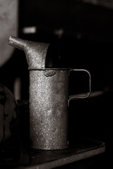 Nahaufnahme im Hochformat einer alten Ölkanne auf einem Tiisch.