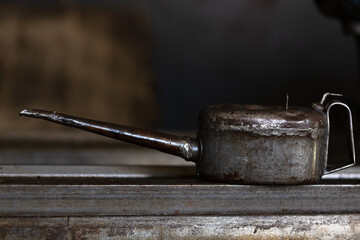 Nahaufnahme einer alten Ölkanne auf einem Tiisch.