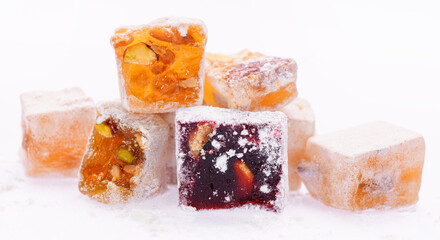 Sweet food Turkish delight, assorted rahat locum in form of cubes with nuts and powdered sugar, traditional food, on white background