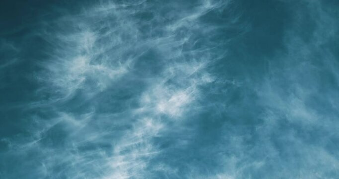 Timelapse of beautiful blue sky with magical white cirrus clouds moving and changing shapes to mysterious and dreamy patterns