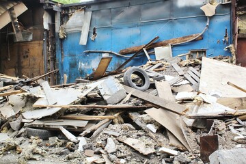 A derelict building with a collapsed wall and a pile of rubble. Concept of decay, abandonment, and urban decay, ruin, destruction, and neglect. Abandoned building with a collapsed wall