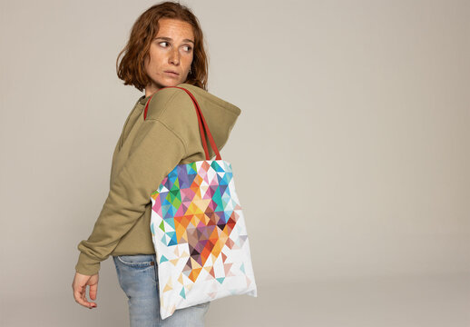 Customizable Tote Bag Showcased by Woman With Red Hair and Freckles. PSD mockup. Insert your design, your logo and change color from bag