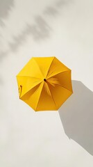 Yellow umbrella overhead, light background, shadow.