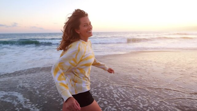 Happy and playful woman at the beach at sunset. Santa Monica California.