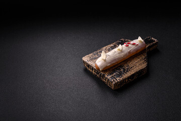 Sweet eclair with chocolate filling covered with white glaze