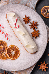 Sweet eclair with chocolate filling covered with white glaze
